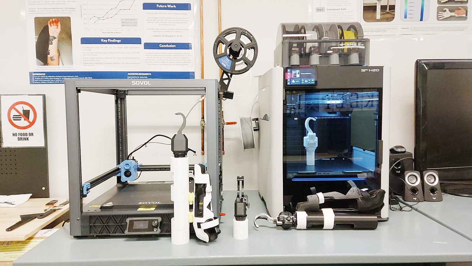 Two 3D printers with printed hooks, grippers and bypass sockets