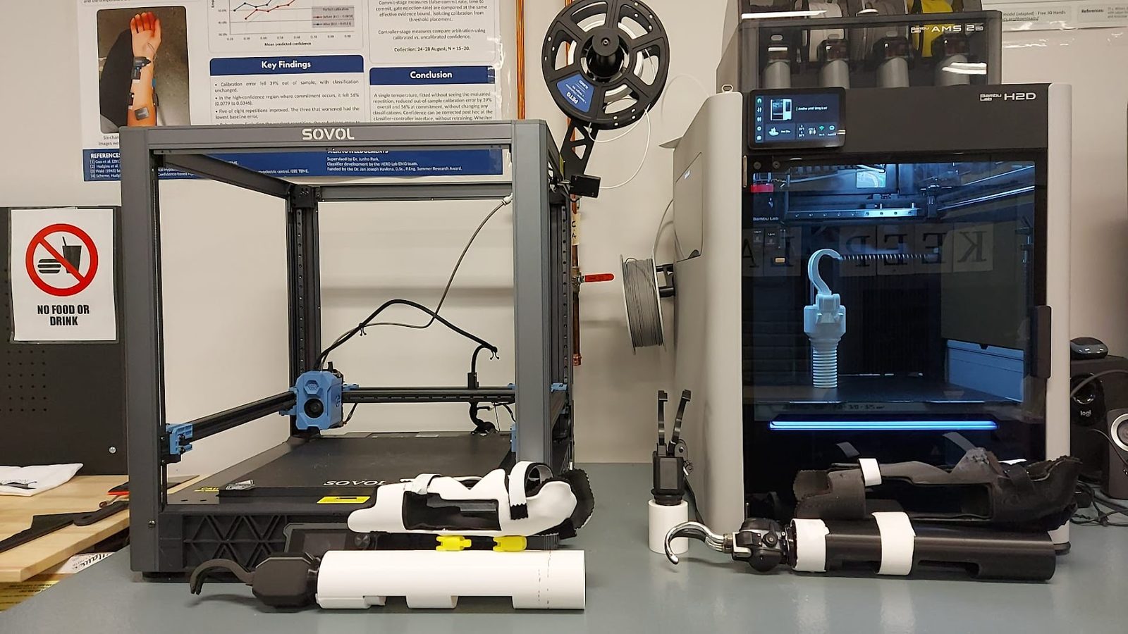 Bambu Lab H2D printing a hook, with printed bypass sockets in front